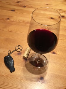 Glass of wine next to a key chain with a car key