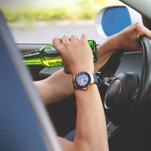 Young man drinking in car